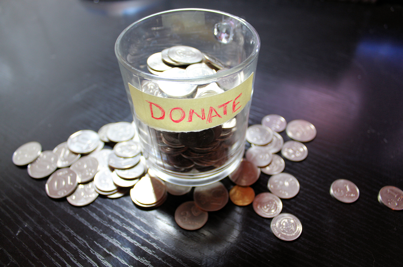 Donation glass with change on a table